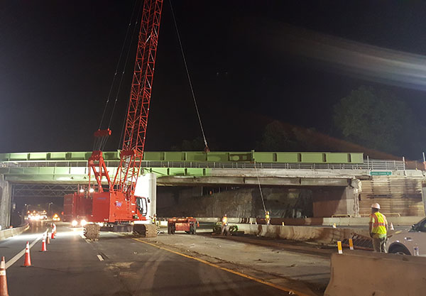 Manitowoc 11000-1 crawler crane hoists a new steel bridge girder into place.